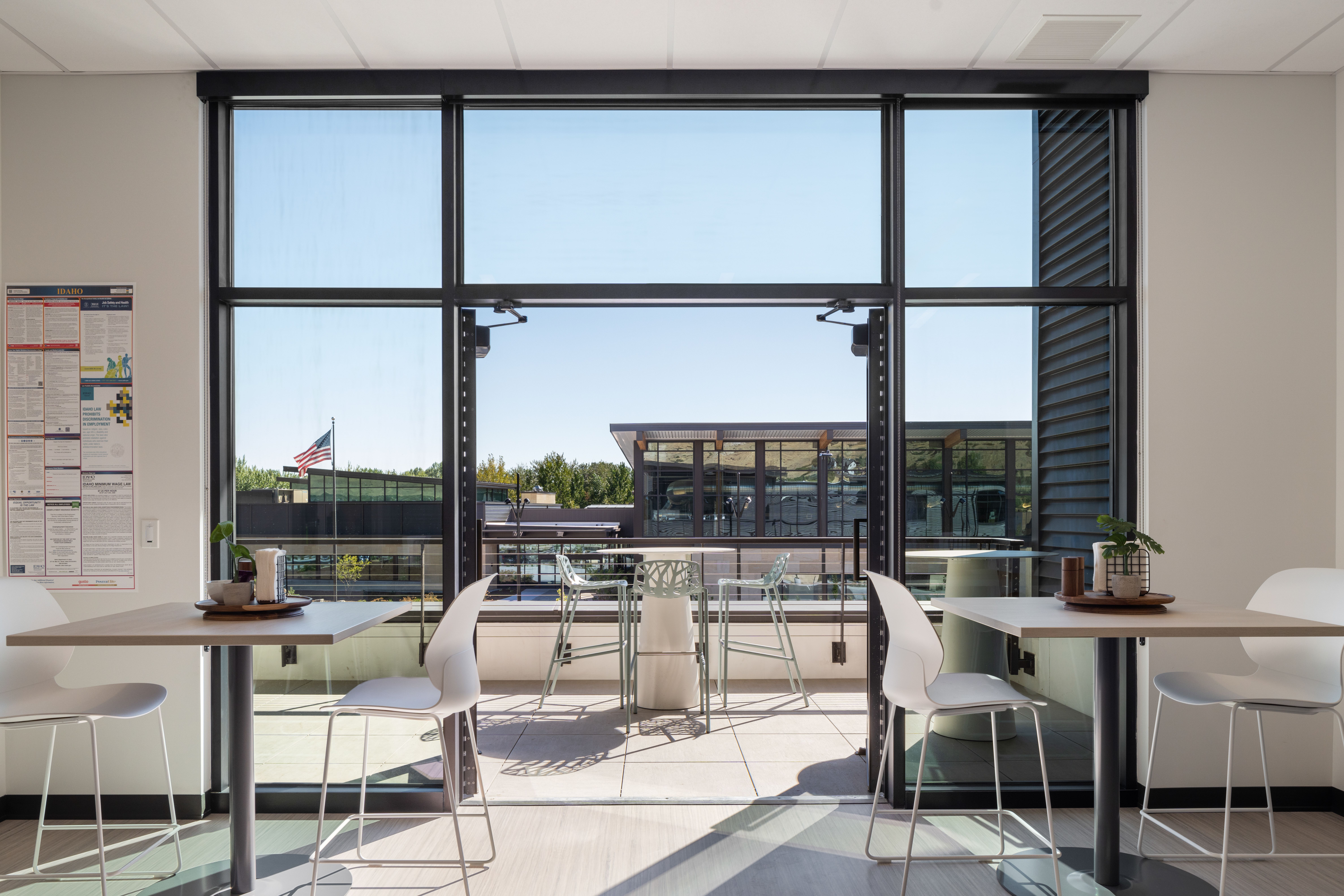 View from the Summit breakroom window overlooking the Idaho Outdoor Fieldhouse, with the U.S. flag and the Fieldhouse entrance visible in the background.