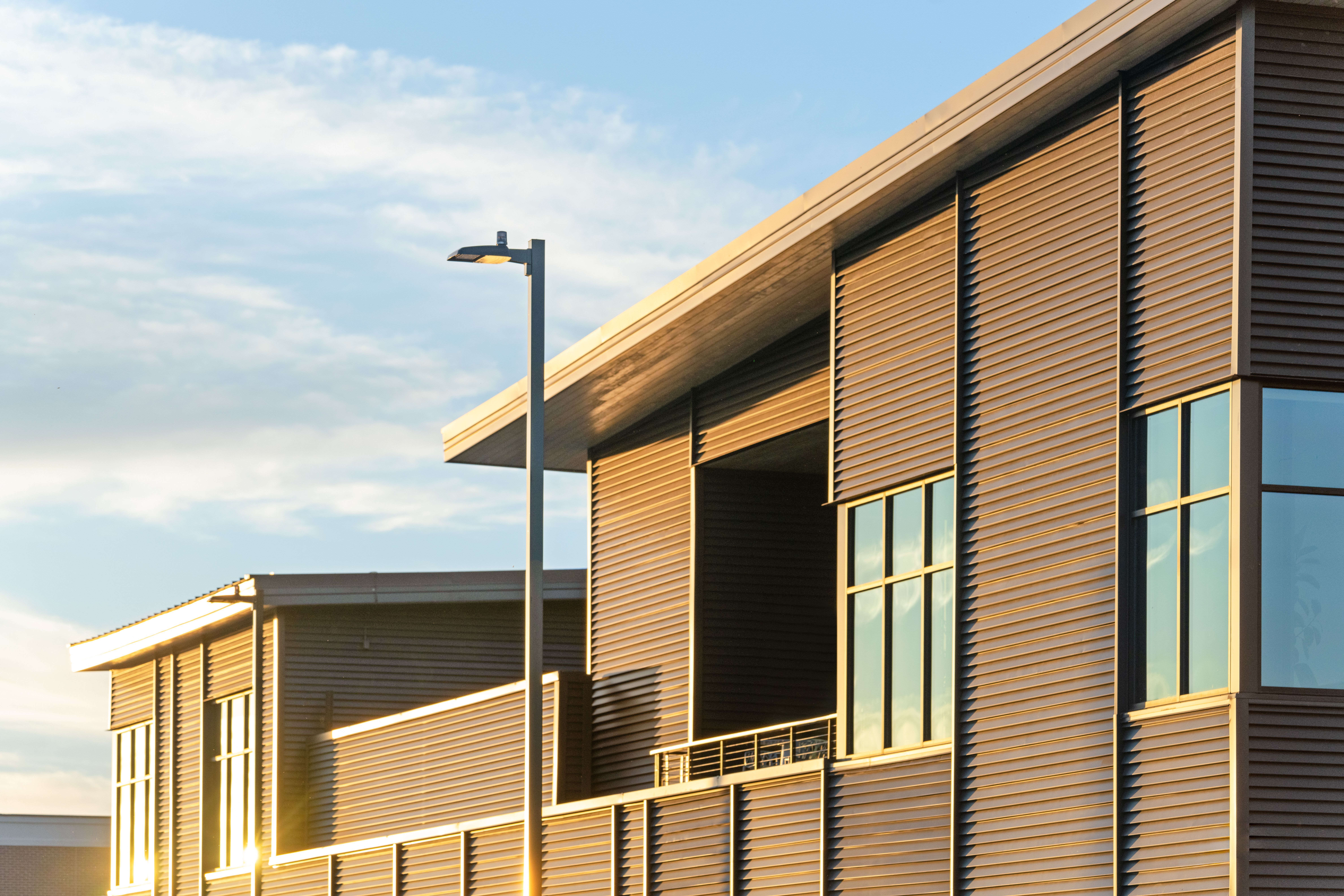 Exterior of the Summit Hyperbarics & Wellness building with large windows, modern architecture, and the surrounding campus visible outside.