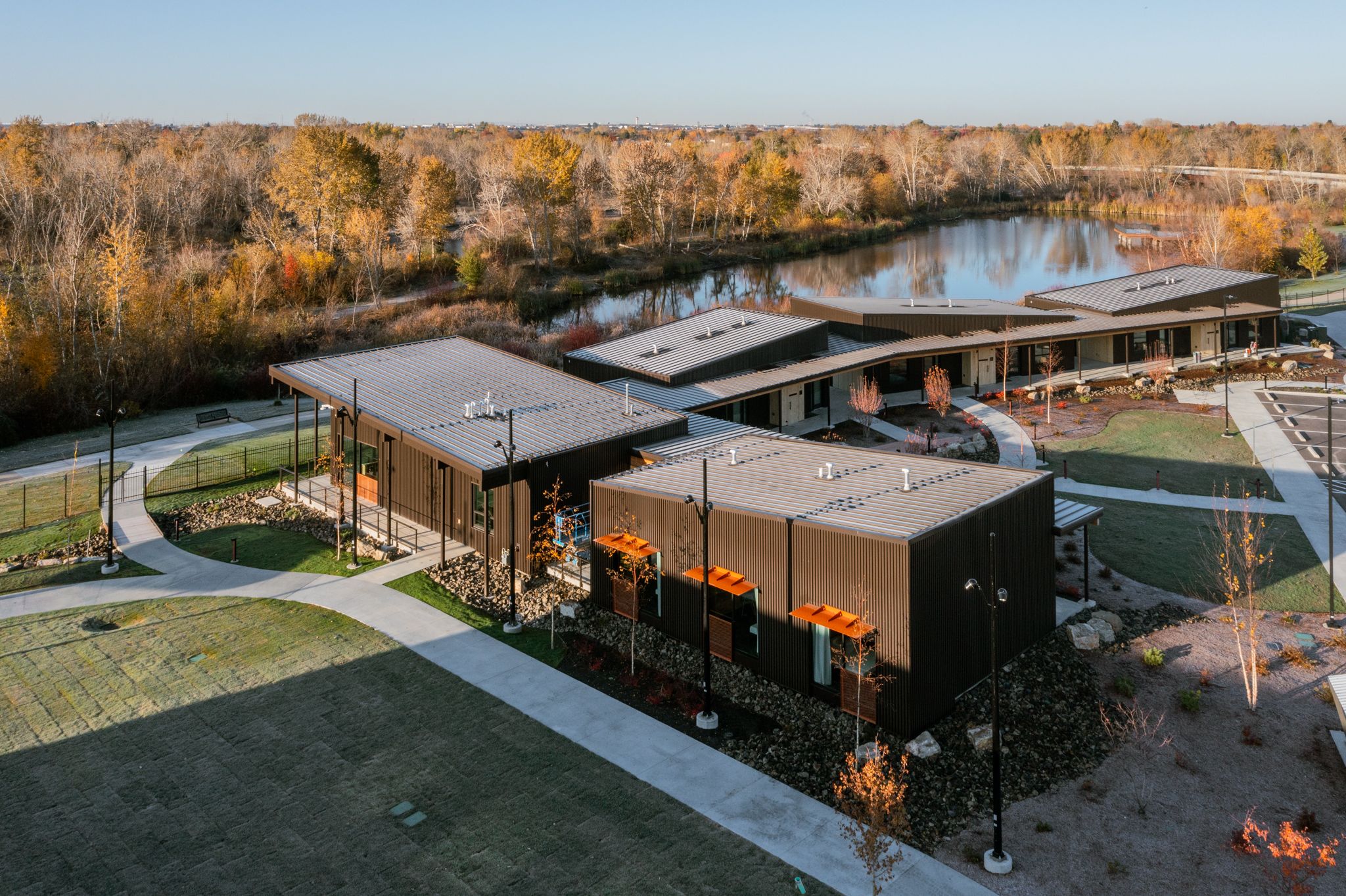 Aerial view of the participant lodging buildings with the lake and trees behind them on the Idaho Outdoor Fieldhouse campus.